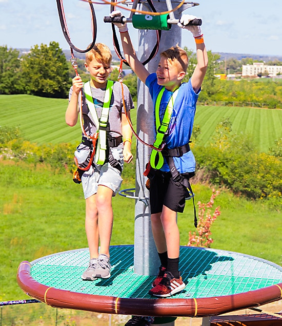 2 boys about to cross on a zip element during a Scout event