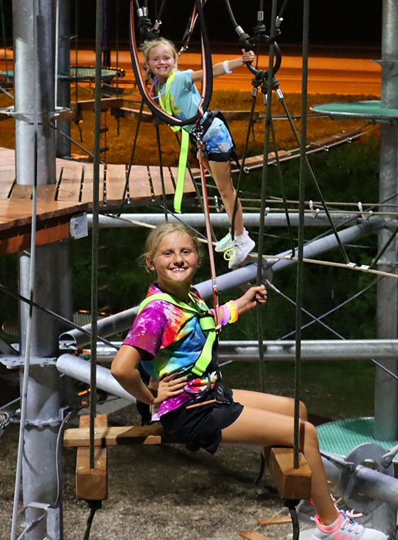 2 young girl playing on adventure tower at an event in St Louis County
