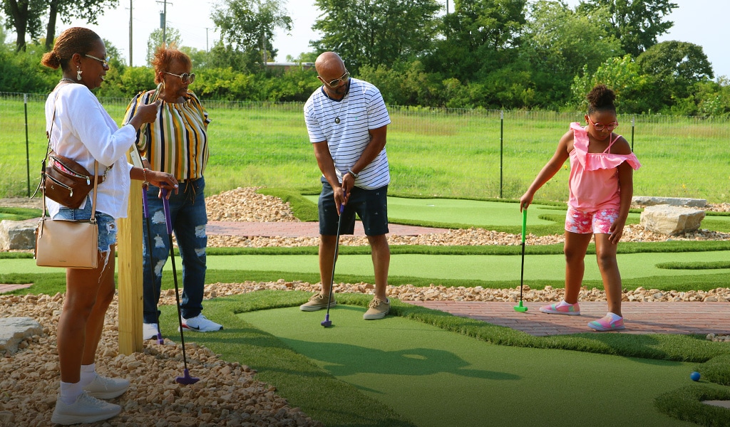 A family enjoying mini golf at Ryze Adventure Park in St. Louis, MO