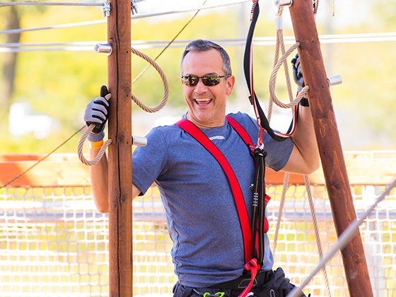 Father smiling as he conquers a challenge on adventure tower