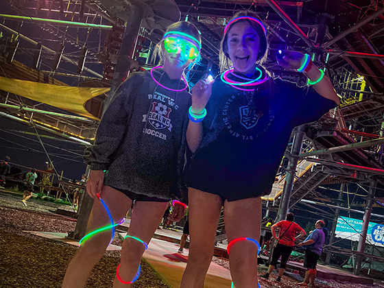 girls with glow sticks, bracelets and more at event