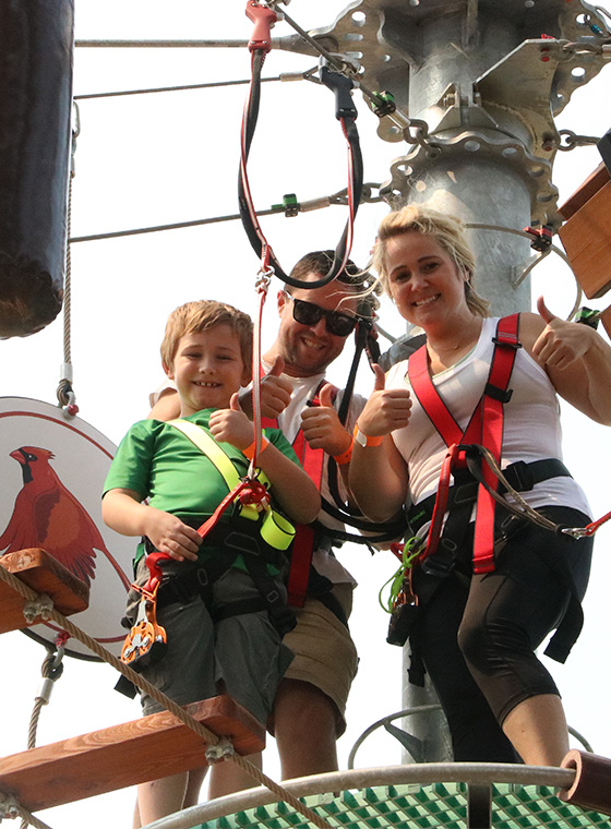 Mom Dad and son on zipline ropes course