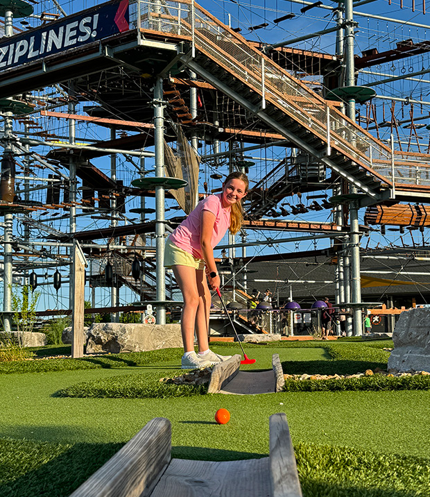 Young girl putting through a mini golf obstacle in St Louis