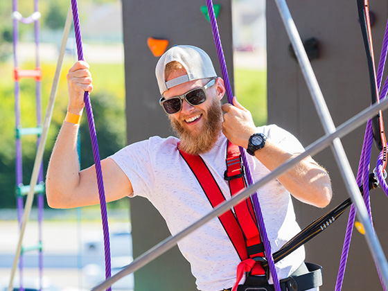 Man climbing on the ropes course in Maryland Heights, MO