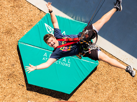 Teenager with arms wide open as he jumps of the platform