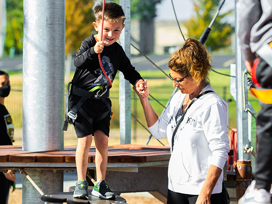 Mom helping a small child on the little ninja course